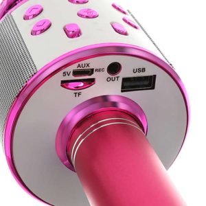 Spodnji pogled na roza karaoke mikrofon, ki prikazuje vhode za USB in SD kartico ter reže.
